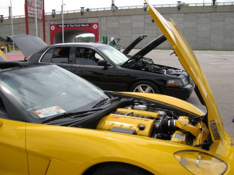 2003 Mercury Marauder - Two cars, a yellow Corvette and a black sedan, are parked with their hoods open.