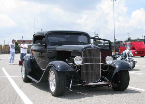 2003 Mercury Marauder - A black hot rod coupe is parked at an outdoor event, with a motorcycle and a red truck visible in the background.