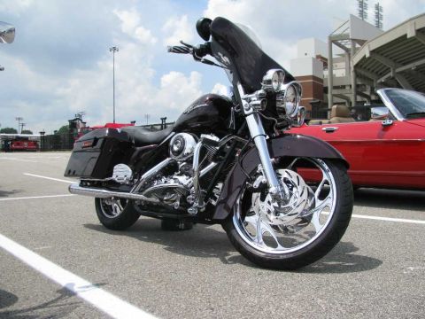 2003 Mercury Marauder - Motorcycle parked next to a red convertible with stadium seating in the background.