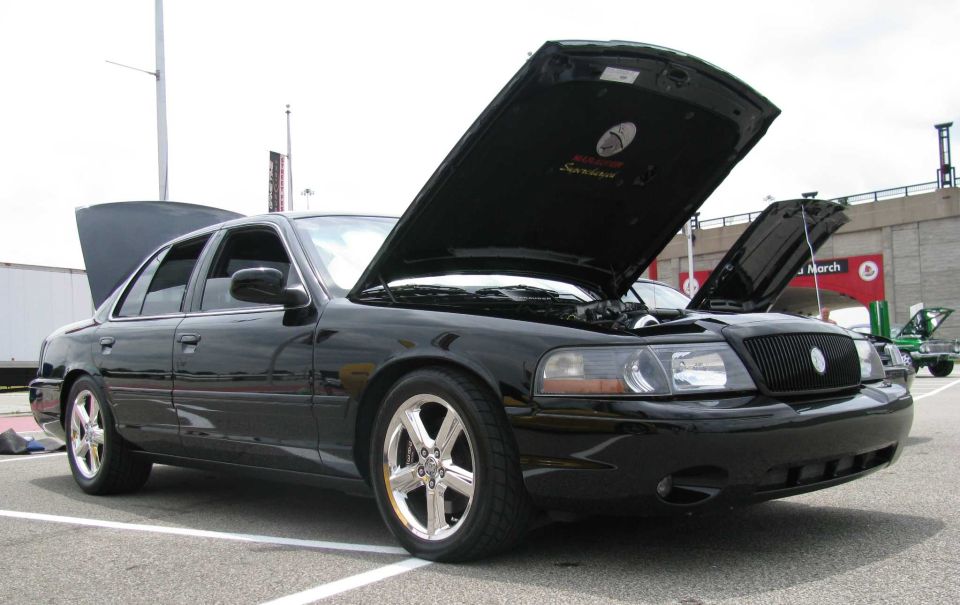 Black 2003 Mercury Marauder with hoods open, showing the engine. Another car is visible in the background