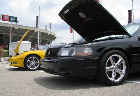 2003 Mercury Marauder - A black 2003 Mercury Marauder is parked at an outdoor event with its hood open, alongside a yellow sports car.