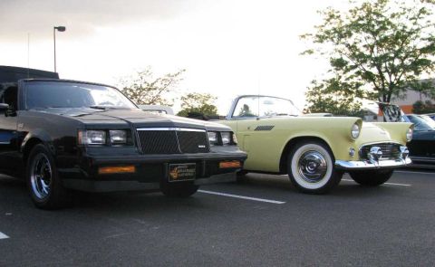 2003 Mercury Marauder - A black coupe and a yellow convertible are parked next to each other at an outdoor event.