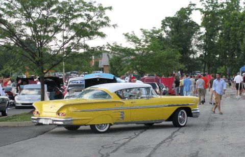 2003 Mercury Marauder - A bright yellow 1958 Chevrolet Bel Air with a white roof is parked at a car show.