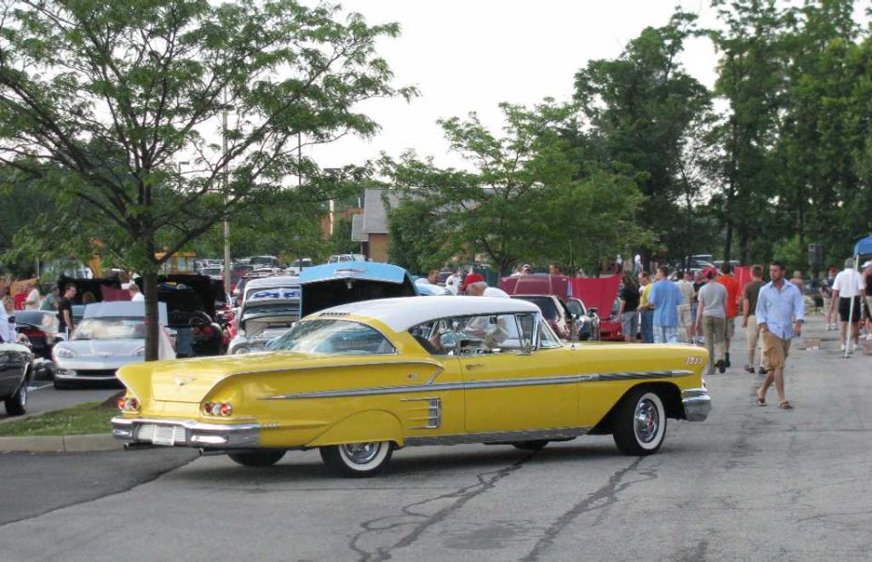 Yellow 1958 Chevrolet Bel Air with white roof, seen from the rear quarter