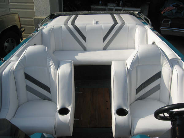 White boat cockpit interior with gray-striped seats and wood-look floor