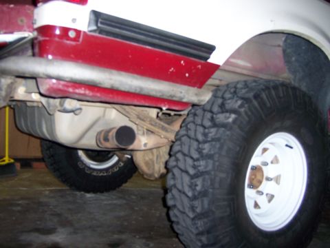 1991 Ford Bronco - Underside view of a truck's rear axle, fuel tank, and exhaust system.