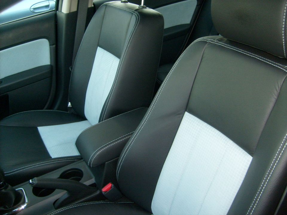 Car front seats in black leather with gray cloth inserts and white stitching