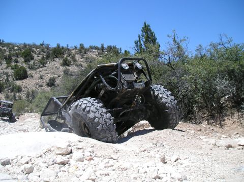 1986 Toyota Hilux - A custom off-road buggy tackles a challenging rocky terrain, with another vehicle visible in the background.