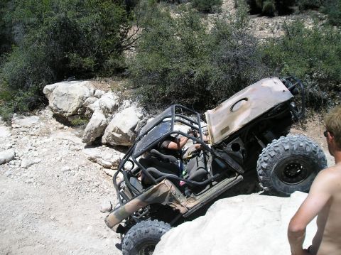 1986 Toyota Hilux - Off-road buggy stuck on rocks with a person watching.