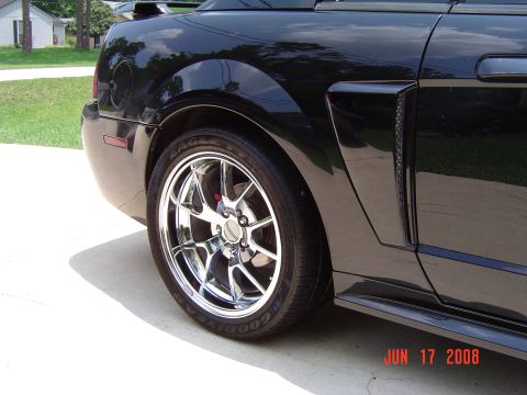 2003 Ford Mustang - Rear view of a black 2003 Ford Mustang showing the quarter panel and a chrome wheel.