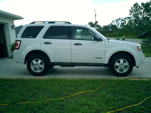 2008 Ford Escape - Side view of a white 2008 Ford Escape parked on a paved surface next to a lawn.
