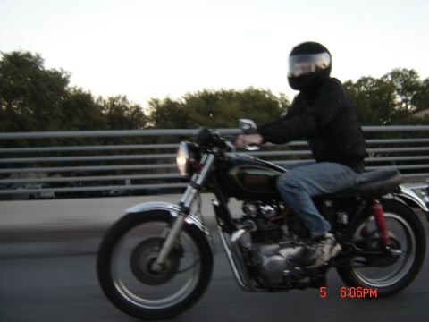 2006 Honda CBR-RR - Rider on a motorcycle on a bridge with trees in the background.