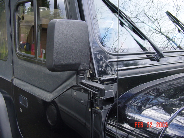 Black SUV exterior door mirror and front fender with raised wiper