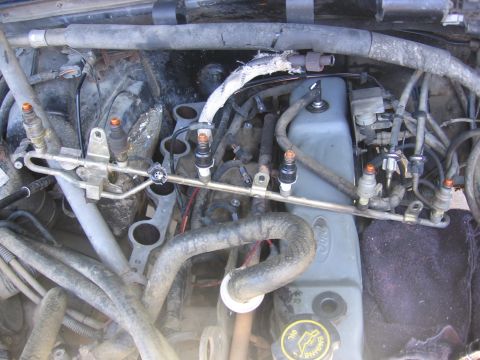 1989 Ford Bronco - Close-up view of engine components, including fuel injectors and a Ford valve cover.