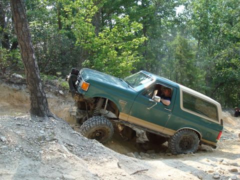 1990 Ford Bronco - This 1990 Ford Bronco navigates a challenging off-road trail with steep inclines and rocky terrain.