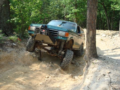1990 Ford Bronco - This 1990 Ford Bronco is navigating a challenging off-road course with steep inclines.