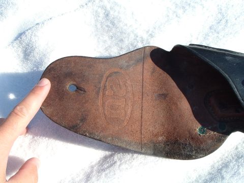 1995 Mercury Grand Marquis - Close-up of a leather part with an embossed logo and a finger pointing to a hole.