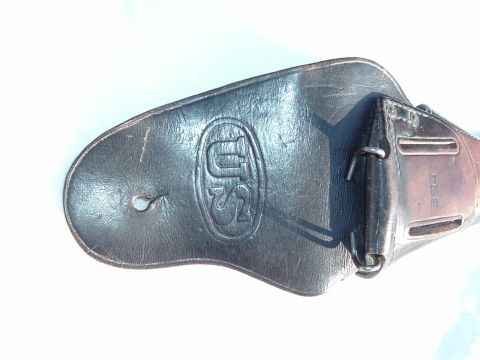 1995 Mercury Grand Marquis - A leather part, possibly a holster or strap, features an embossed US insignia and metal fasteners.