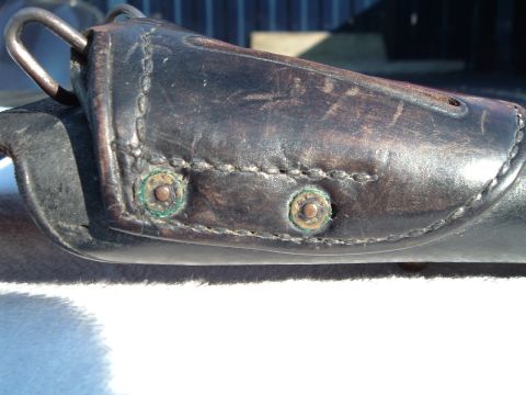 1995 Mercury Grand Marquis - Close-up of a worn leather holster with visible stitching and brass rivets, a metal loop at the top.