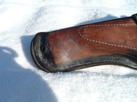 1995 Mercury Grand Marquis - A close-up view of a worn leather gun holster with visible stitching and black trim.