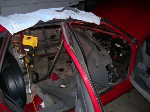 1992 Ford Taurus - The interior of a car is disassembled, with the dashboard removed and various wires and components exposed.