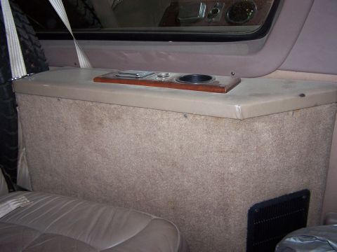 1995 Ford C-350 (Centurion Conversions) - Interior view of a vehicle's console area, showing a cup holder and storage.