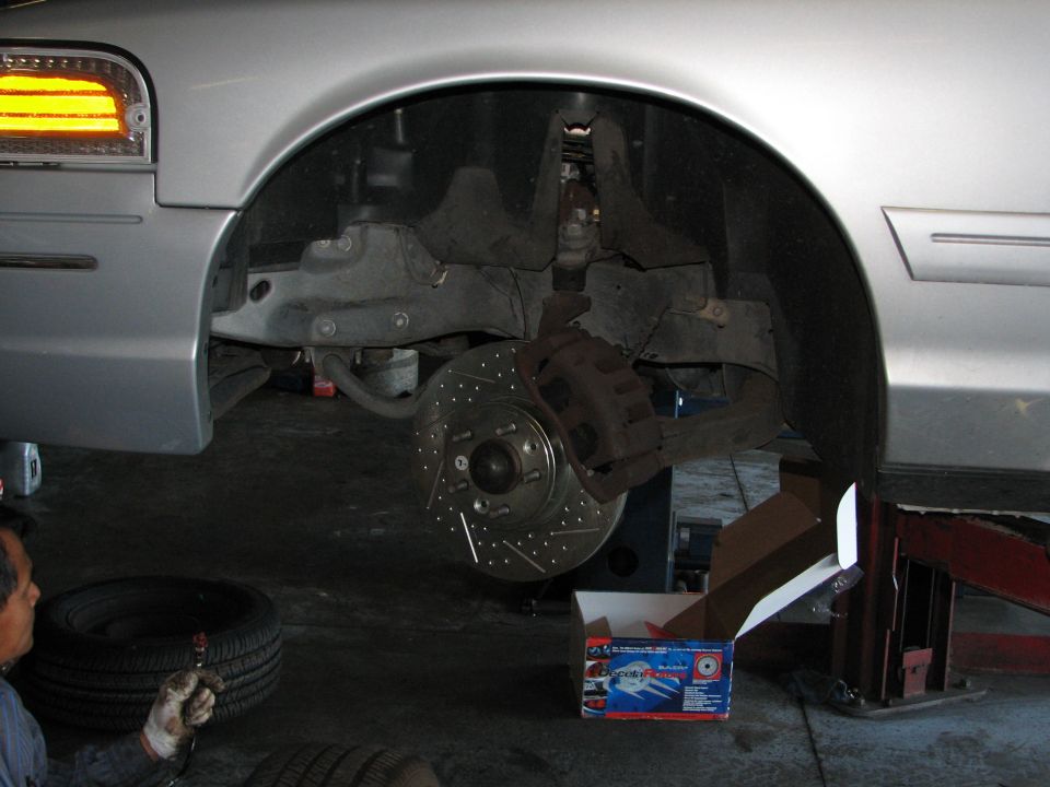 2002 Ford Crown Victoria front brake assembly with drilled rotors and new pads in box