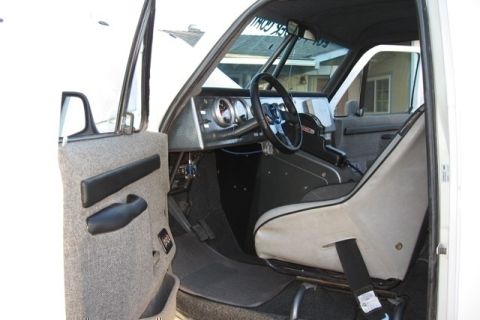 1988 Ford Bronco - The interior of the vehicle features a custom dashboard with gauges and a racing-style seat.