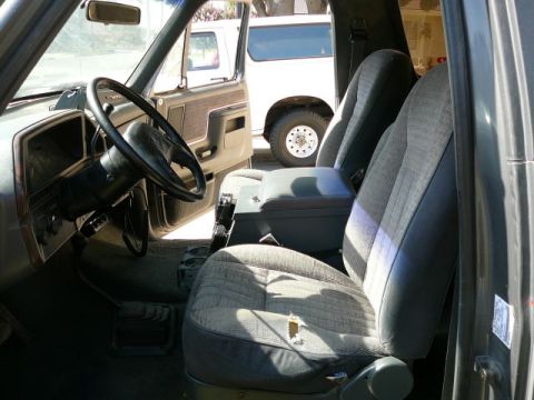 1988 Ford Bronco - Interior view of a 1988 Ford Bronco, with a second Bronco visible through the open door.