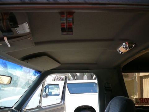 1988 Ford Bronco - Interior view looking up at the gray cloth headliner of a truck-based SUV, showing the overhead console area, a small dome/map light with r…