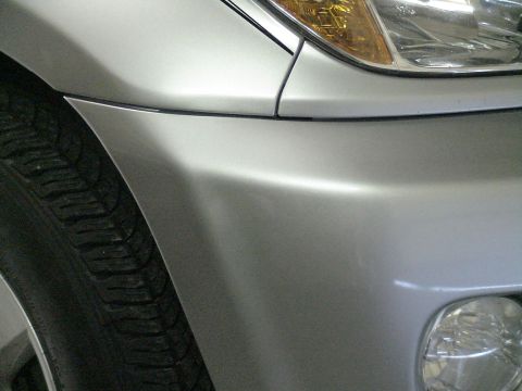 1993 Ford C-350 (Centurion Conversions) - Close-up of a silver front bumper and headlight assembly on a vehicle.