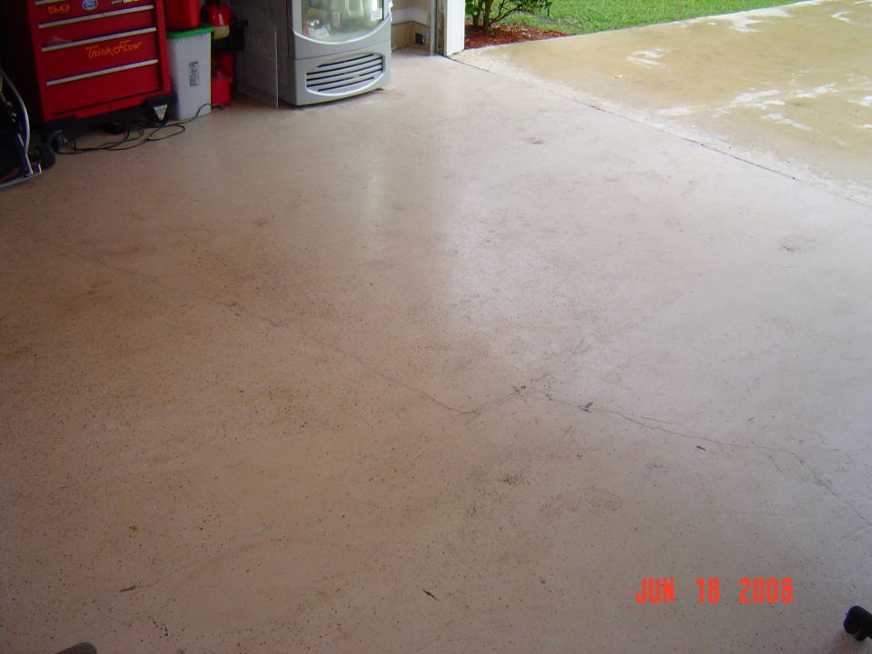 Empty bare concrete garage floor with a red tool chest and space heater