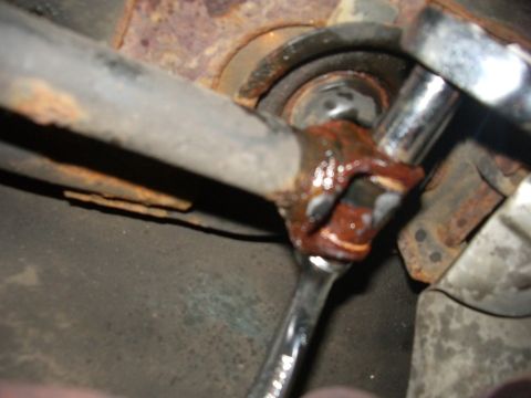 1995 Ford Probe - Mechanic uses a wrench on a corroded suspension component, likely during a repair or modification.
