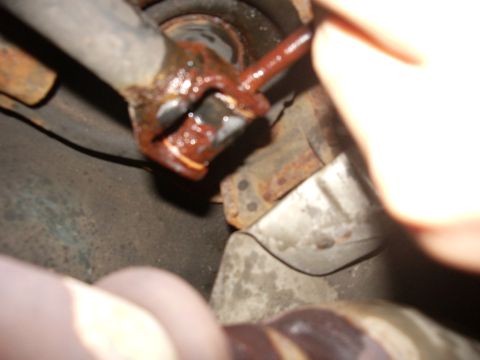 1995 Ford Probe - Close-up view of a corroded exhaust pipe connection, possibly indicating a need for repair or replacement.