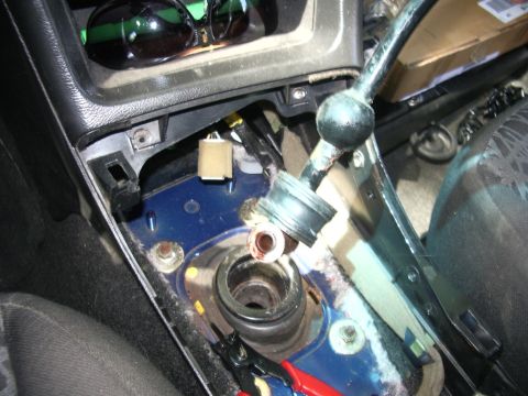 1995 Ford Probe - The center console is disassembled around the gear shifter, revealing internal components and wiring for a short shifter installation.