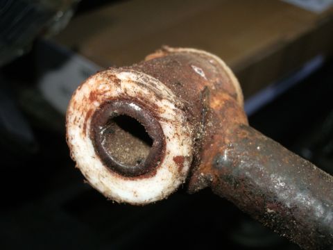 1995 Ford Probe - This image shows a corroded metal part with a white bushing, likely a worn component from a vehicle.