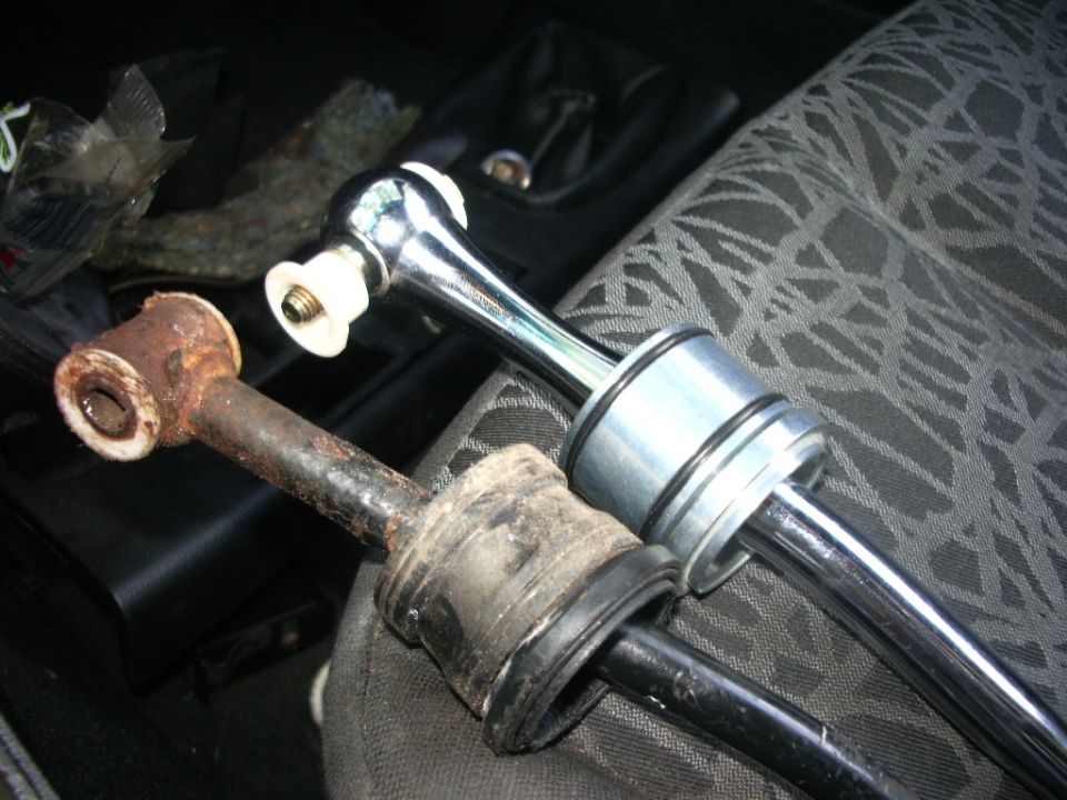 old rusty shifter linkage next to a new chrome shifter assembly