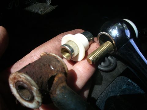 1995 Ford Probe - Close-up of a hand holding a rusty car part and a chrome shifter assembly.
