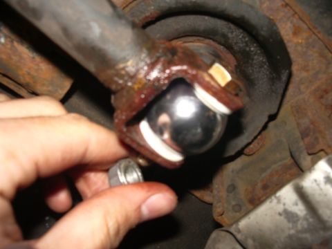 1995 Ford Probe - Close-up of a ball joint connection, with a hand holding a nut nearby.