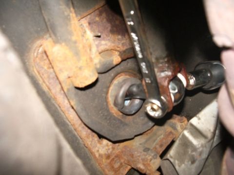 1995 Ford Probe - Close-up of a wrench tightening a bolt on a rusty automotive component, likely during a repair or modification.