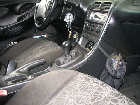 1995 Ford Probe - The interior of a car is shown, focusing on the center console, gear shifter, and part of the dashboard.