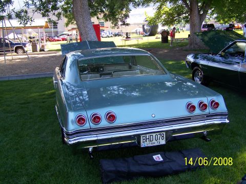 1972 Ford Ranchero - Rear view of a light blue 1965 Chevrolet Impala sedan at an outdoor car show.