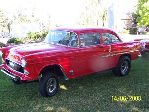 1972 Ford Ranchero - A red 1955 Chevrolet Bel Air sedan is parked on a grassy lawn, showing its drag racing tires.