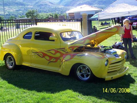 1972 Ford Ranchero - A yellow coupe with flame decals is displayed with its hood open at an outdoor event.