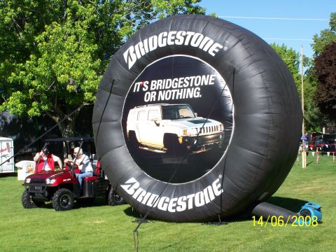1972 Ford Ranchero - An outdoor event features a large inflatable tire display and a golf cart on a grassy field under a clear blue sky.