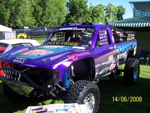 1972 Ford Ranchero - This modified Toyota truck displays numerous sponsor decals and a distinctive shark-tooth grille design.