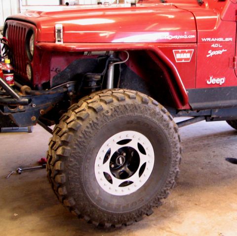 1995 Ford Bronco - A red Jeep Wrangler is shown with off-road modifications, including large tires and a winch.