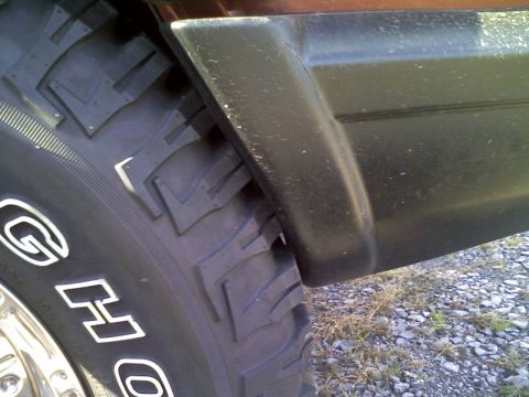 1998 Jeep Cherokee - Close-up of a 1998 Jeep Cherokee's fender flare and tire, indicating flex or rubbing testing.