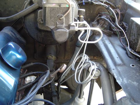 1978 Ford Bronco - Close-up view of the brake master cylinder and associated plumbing and wiring in an engine bay.