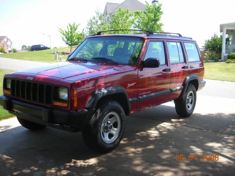 1998 Jeep Cherokee - Red 1998 Jeep Cherokee Sport SUV parked on a driveway with a house in the background.